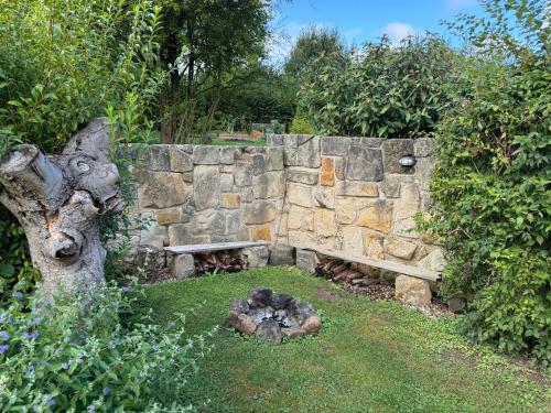 a stone wall with a bench next to a tree at Kamenny apartman in Libunec