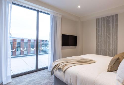 a bedroom with a bed and a large window at Sudima Christchurch City in Christchurch