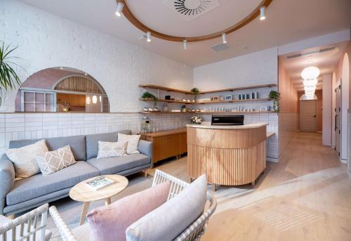 a living room with a couch and a kitchen at Sudima Christchurch City in Christchurch