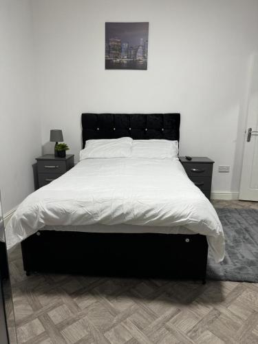 a bedroom with a large bed with white sheets at 1 bedroom kitchen Flat in Nottingham