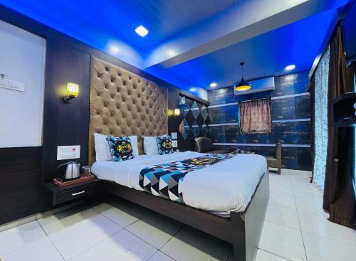 a bedroom with a large bed with a blue ceiling at Hotel Neelkiran in Navi Mumbai