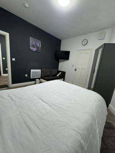 a bedroom with a white bed and a couch at 1 bedroom kitchen Flat in Nottingham
