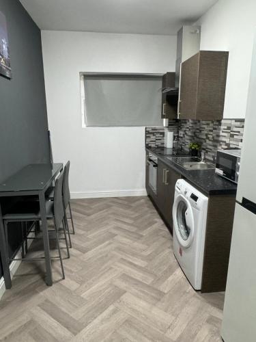 a kitchen with a washing machine and a table at 1 bedroom kitchen Flat in Nottingham