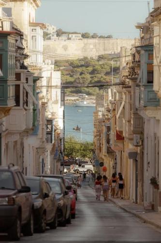 a city street with cars and people walking down the street at Authentic Townhouse with backyard in Sliema by 360 Estates in Sliema