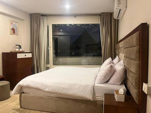 a bedroom with a large bed and a window at prestige pyramids INN in Cairo