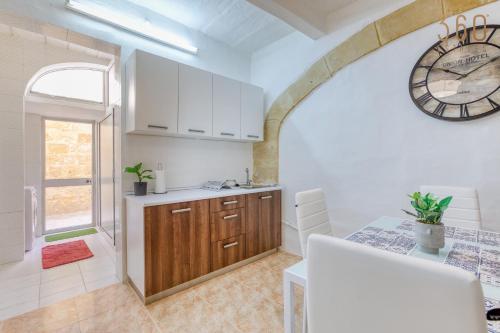 a kitchen with a large clock on the wall at Authentic Townhouse with backyard in Sliema by 360 Estates in Sliema