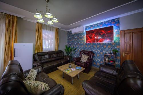 a living room with leather couches and a table at Álomkert Vendégház in Békésszentandrás