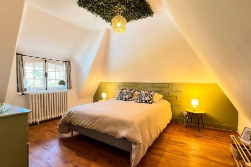 une chambre avec un grand lit dans un grenier dans l'établissement Belle maison Normande 8pers avec piscine au calme, à Drucourt