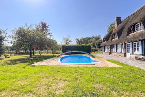 une piscine dans une cour à côté d'une maison dans l'établissement Belle maison Normande 8pers avec piscine au calme, à Drucourt