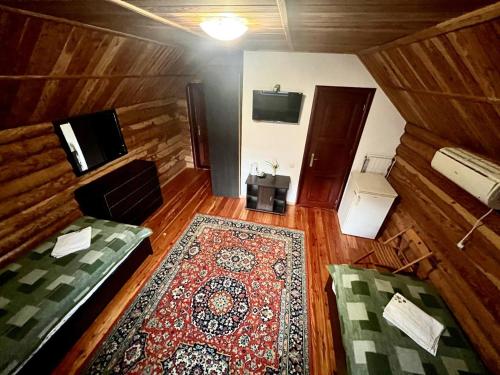 a room with two beds and a rug and a tv at Комфорт in Polyana
