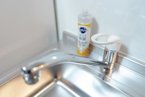 lavandino con rubinetto e bottiglia di dentifricio di L house 101 ad Osaka