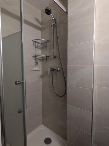 une douche dans une salle de bain avec une porte vitrée dans l'établissement Maison de vacances au bord de la marina, WIFI, clim, à Saint Cyprien Plage