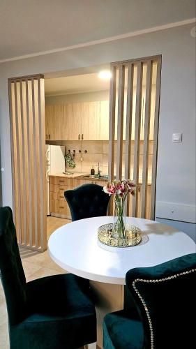 a table with chairs and a vase of flowers on it at Tiha Voda 1 in Požarevac