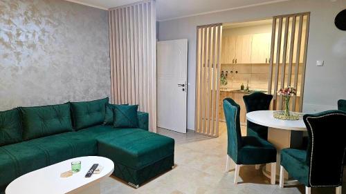 a living room with a green couch and a table at Tiha Voda 1 in Požarevac