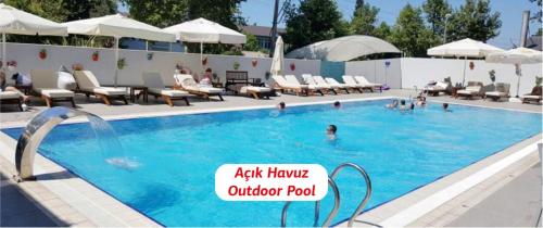 a pool with chairs and people in the water at Yalova Lova Hotel & SPA Yalova in Yalova