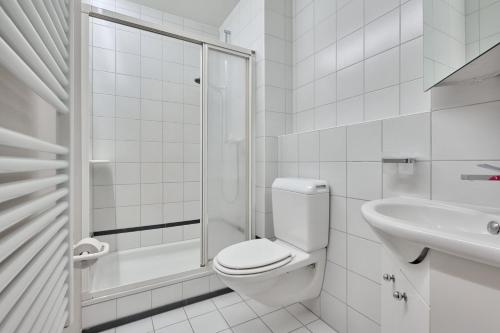 a white bathroom with a toilet and a sink at Chesa Madrisa in St. Moritz