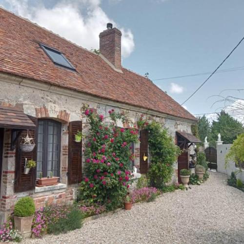 an old house with flowers on the side of it at LE VIEIL HERMITAGE in Ervauville
