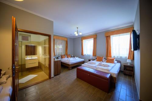 a hotel room with two beds and a bathroom at Álomkert Vendégház in Békésszentandrás
