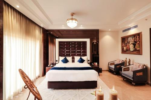 a bedroom with a king sized bed and a couch at Hukam's Lalit Mahal - Hotel Convention Club in Raipur
