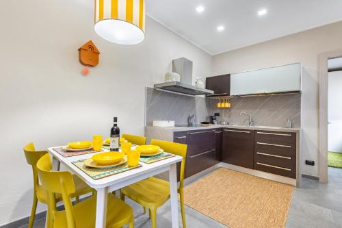 a kitchen and dining room with a table and yellow chairs at Palazzo Stupino - Il Duomo in Alba