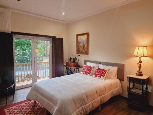 a bedroom with a large white bed with red pillows at Casa dos Trigais in Marco de Canaveses