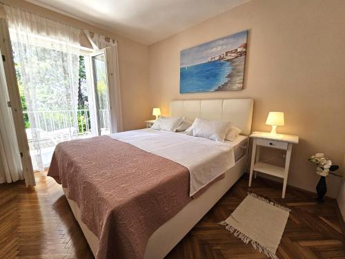 a bedroom with a large bed and a large window at Apartments Mirko in Malinska