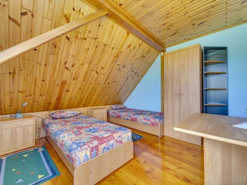 a room with two beds in a wooden room at Holiday Home Borówna-1 by Interhome in Lipnica Górna