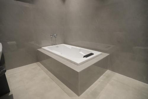 a white bath tub in a bathroom with a sink at The Golden Glow by Ivory Stays in Udaipur