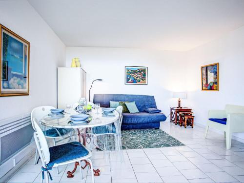 un salon avec une table et un canapé bleu dans l'établissement Apartment Les Terrasses du Levant-24 by Interhome, à Canet