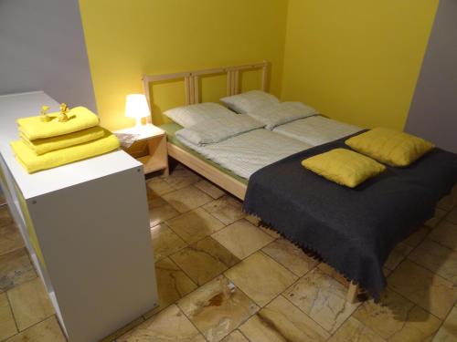Apartamenty Polna في كاليش: غرفة نوم عليها سرير ومخدات صفراء