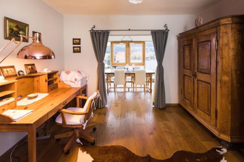 a home office with a wooden desk and a dining room at Chalet Almblick in Fischbach