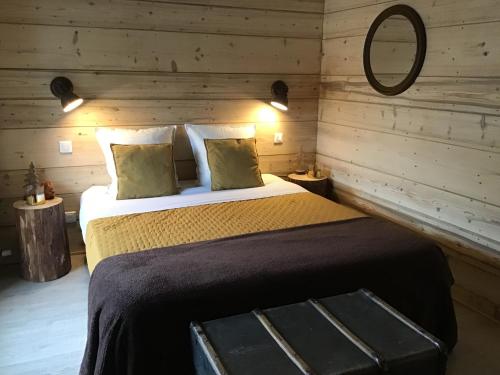 a bedroom with a bed in a wooden room at Au charmant chablis in Champagnole