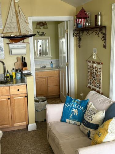 a living room with a couch and a kitchen at The Highland Cottage on Sheepscot in Edgecomb