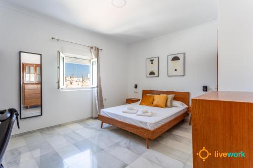 a bedroom with a bed and a window at Torre Argantonio by LiveWork in Cádiz