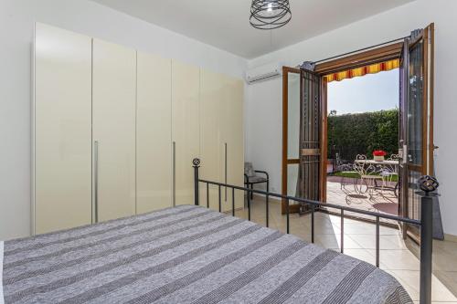 a bedroom with a bed and a view of a patio at Villa Di Mauro in Viagrande