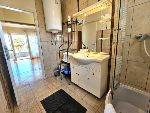a bathroom with a sink and a shower and a tub at Apartments Mirko in Malinska
