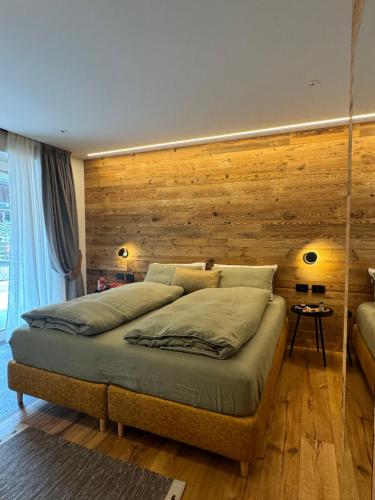 a bedroom with two beds and a wooden wall at Lisa Da Pent in Canazei