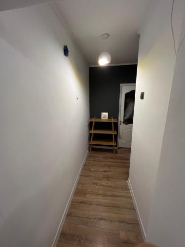 a hallway with a white wall and a wooden floor at Rent&live part apartment in Codru
