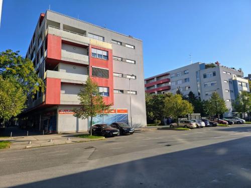 a parking lot with cars parked in front of a building at Studio apartment Zen Zagreb with free garage in Zagreb