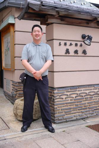a man is standing in front of a building at Honjin Hiranoya Kachoan in Takayama