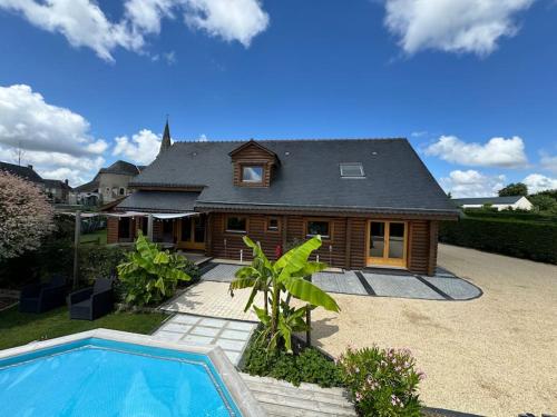 une maison avec une piscine devant dans l'établissement Le Chalet aux Trésors !, à Notre-Dame-dʼAllençon