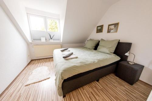une petite chambre avec un lit et une fenêtre dans l'établissement Großzügiges Wohlfühlhaus zwischen Stadt & Meer, à Hinte