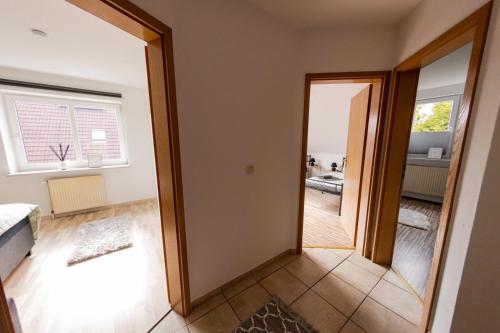 un couloir avec une porte menant à un salon dans l'établissement Großzügiges Wohlfühlhaus zwischen Stadt & Meer, à Hinte