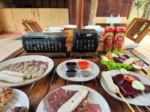 a wooden table with plates of food on it at Longoza Ecolodge in Andasibe