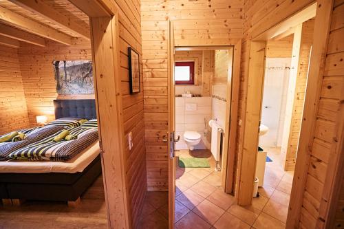 a bedroom with a bed in a wooden cabin at EifelGlückVII in Rieden