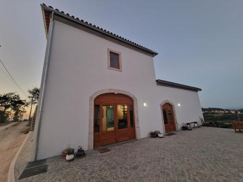 a white church with a wooden door on a street at Quinta da Chumbaria - heaven on a hilltop, peace and stunning views! in Casal do Monte