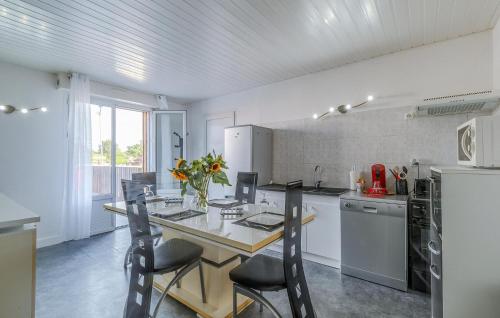 une cuisine avec une table, des chaises et un réfrigérateur dans l'établissement 1 Bedroom Stunning Apartment In Médis, à Médis