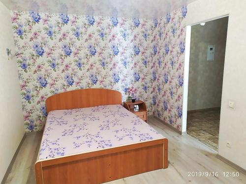 a bedroom with a bed and a floral wallpaper at Apartment - Generala Petrova Street in Odesa