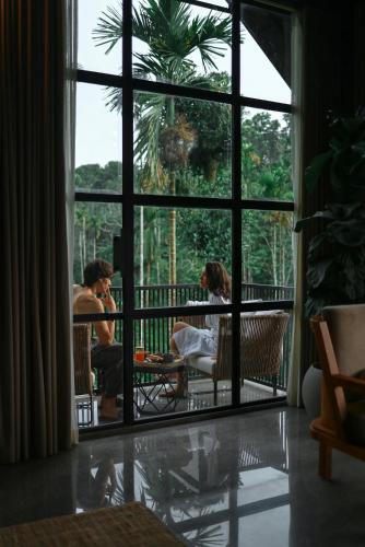 a group of people sitting on a balcony looking out the window at Bhadra - The Estate Villa in Wayanad