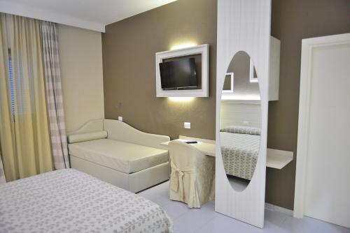 Habitación pequeña con cama y TV. en Hotel Degli Ulivi, en Ferrandina